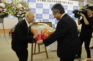 中=田中亮一郎・第一交通産業社長(右)が黒土始・第一交通産業創業者会長(左)に花束を贈呈